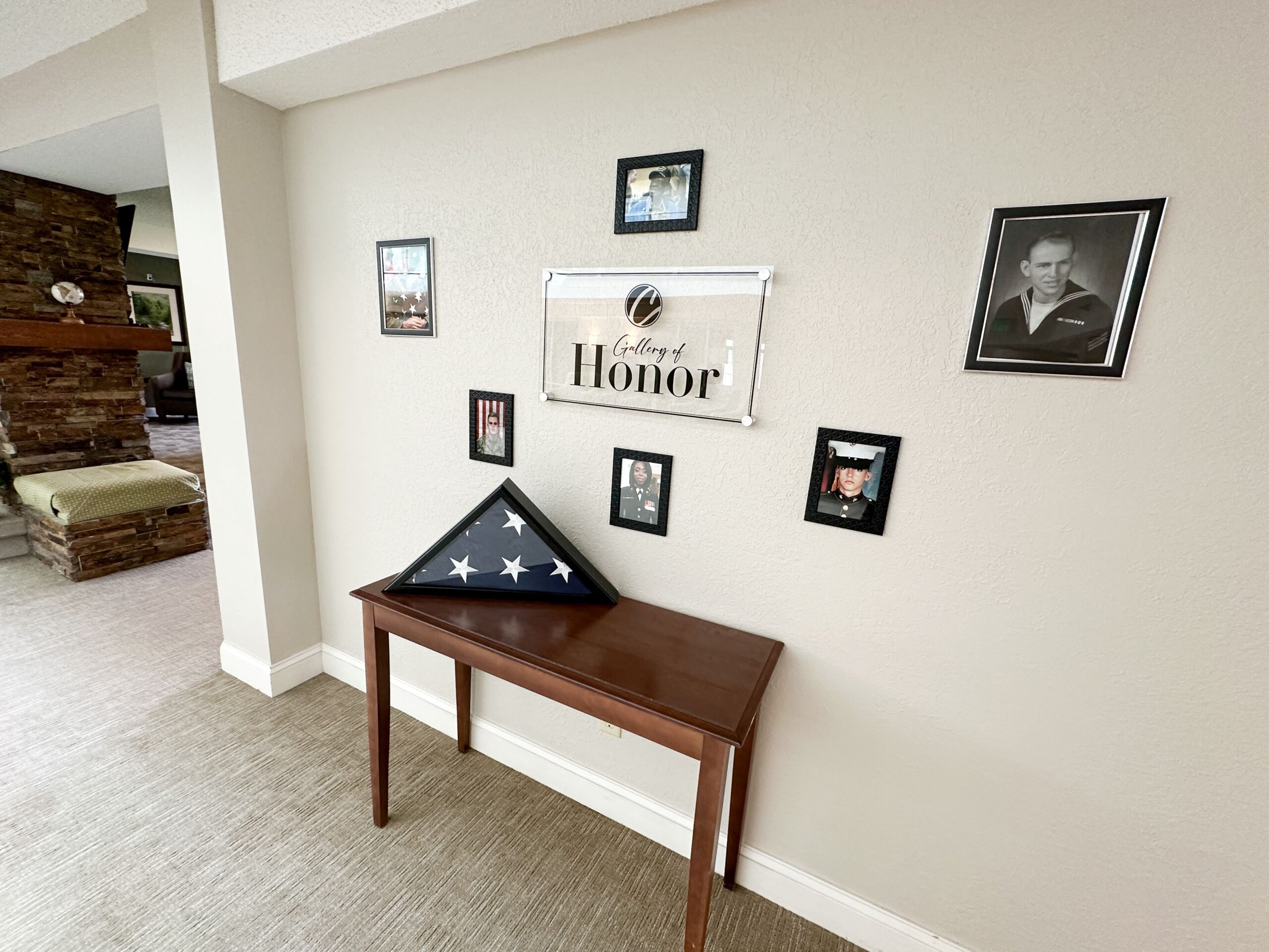 Gallery of Honor with photos of military members and folded American Flag